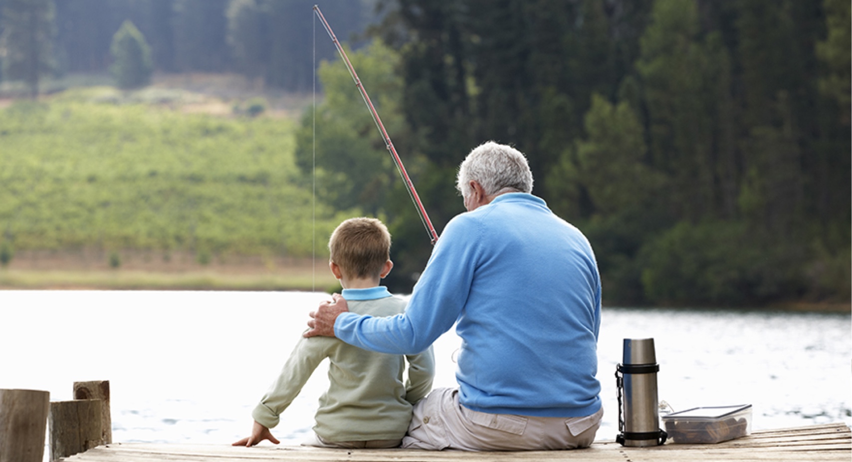 A man and boy fishing on the dock.